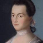 Portrait of Abigail Adams as a young woman. She is wearing a blue dress with a lace trim and wears white pearls around her neck, and has a serene expression with a small smile on her face.